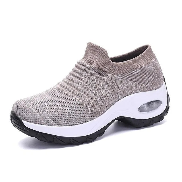 Red and black knitted slip-on trainers with burgundy sole worn with rolled-up jeans