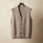 Beige knitted waistcoat with V-neck and dark buttons, hanging on a wooden hanger against a neutral backdrop