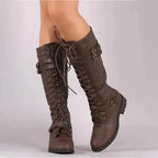 Side view of dark brown lace-up knee-high boots showing the treaded sole and buckle detail.