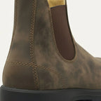 Close-up of the heel and elastic gusset on a weathered brown leather Chelsea boot