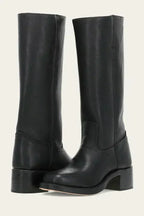 Close-up of stacked wooden block heel and leather sole on a dark brown boot