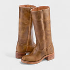 Knee-high light brown leather boots with visible grain texture, tan stacked heel and contrast topstitching