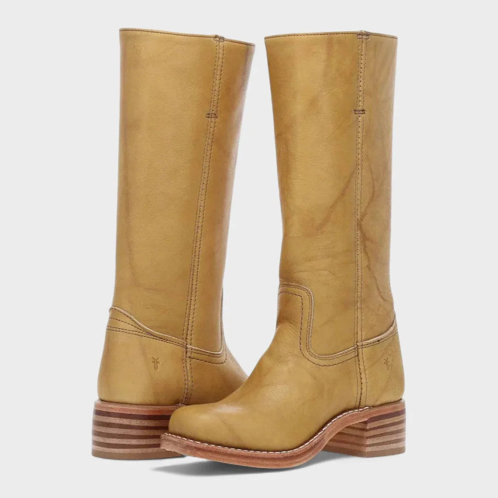 Tall mustard yellow leather boots shown together, showcasing the smooth finish and curved western-style seam