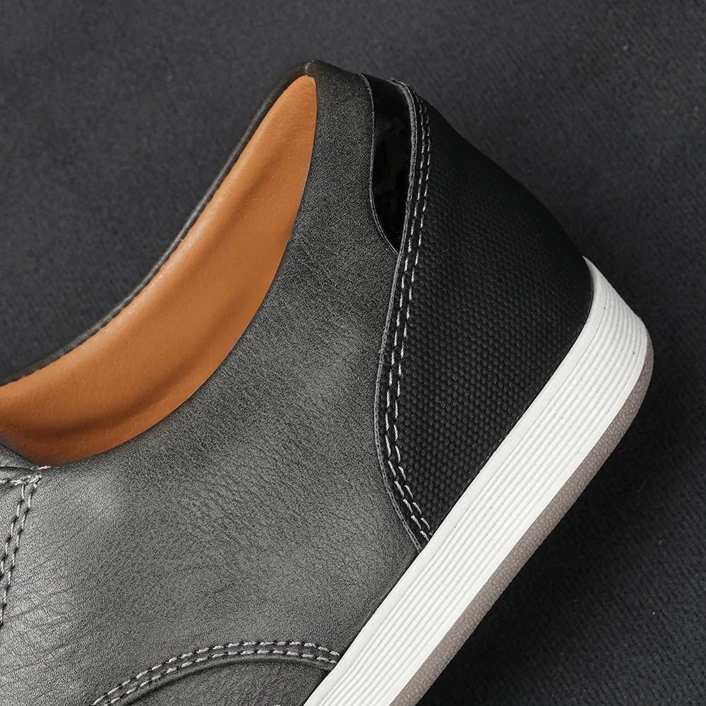 Close-up of the padded heel collar showing tan leather lining, grey leather upper and contrast stitching detail