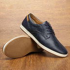 Side view of brown leather lace-up trainer highlighting grain texture, tan laces and cushioned tan footbed