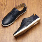 Navy leather trainer on plain white background showing lace-up front, rounded toe and white rubber sole