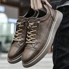 Close-up of the black leather trainer upper with visible stitched panel lines across the front