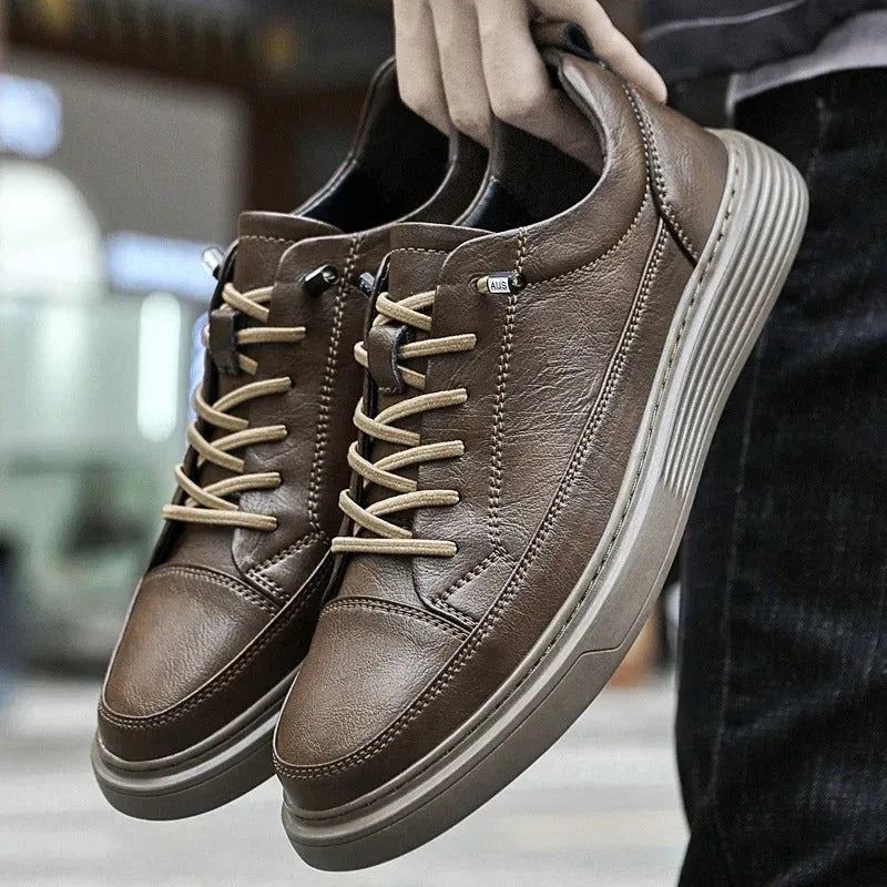 Close-up of the black leather trainer upper with visible stitched panel lines across the front