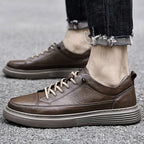 Black leather trainer paired with distressed denim, showing the laced vamp from above