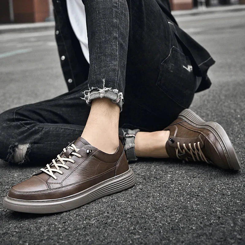 Black leather trainer shown on a tarmac surface with natural daylight