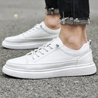 Black leather trainer worn outdoors with cuffed denim jeans and visible ankle