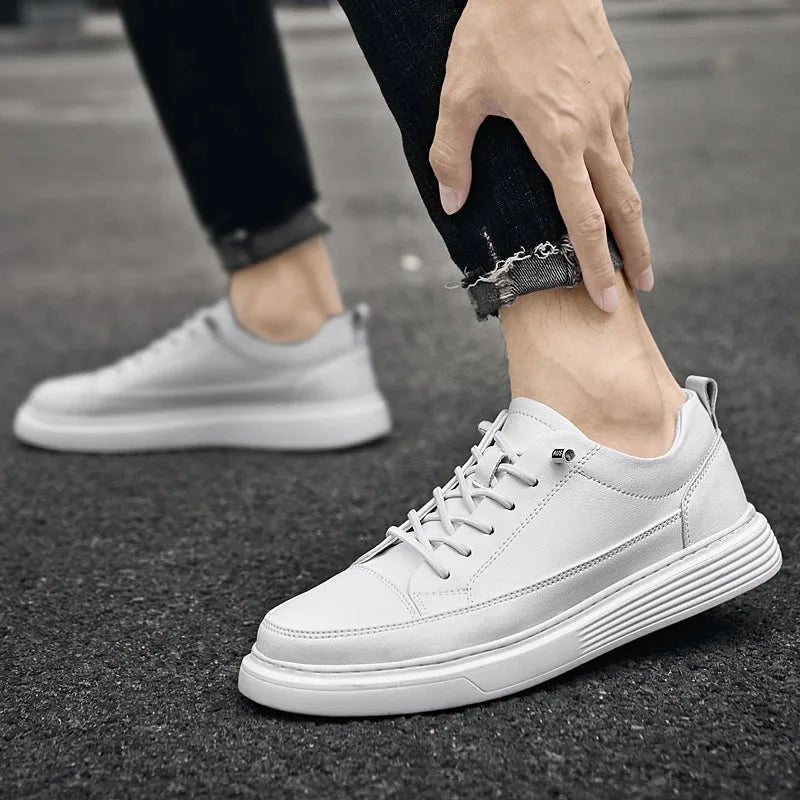 Side angle of a black leather trainer showing the smooth leather panel and seam detail