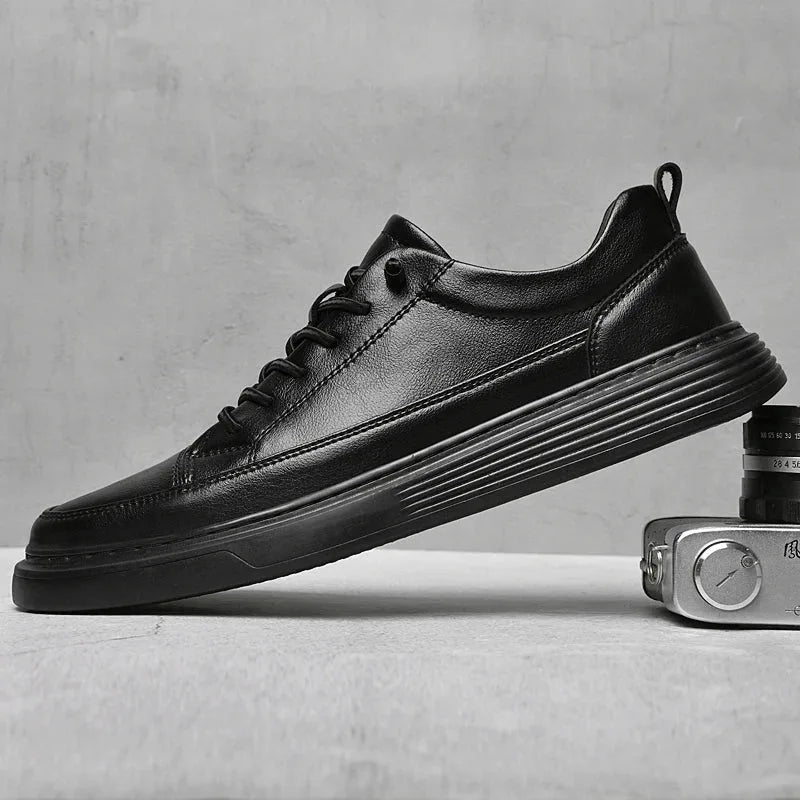 Studio shot of a single black leather trainer resting against a vintage camera, smooth upper finish