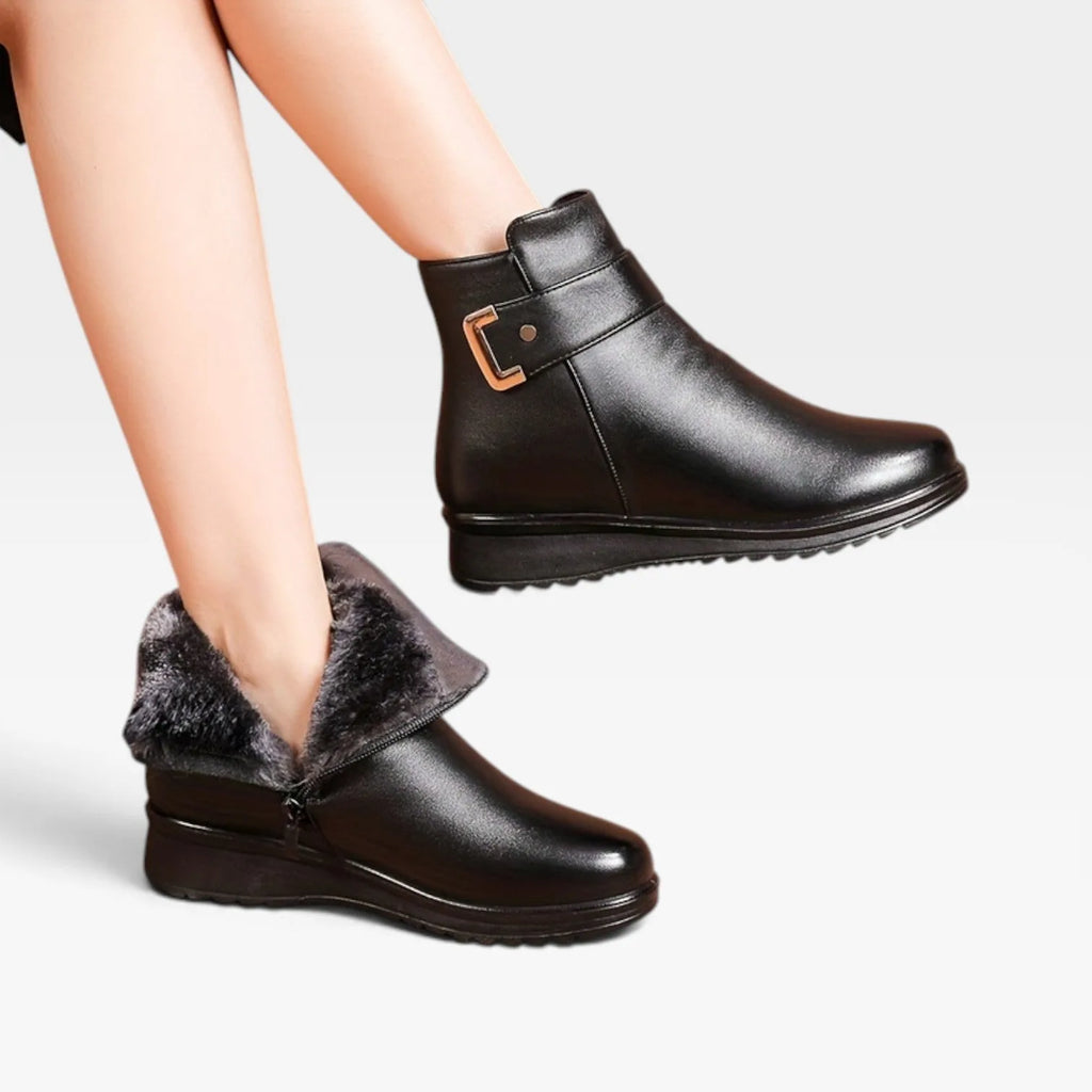Model wearing black leather ankle boots with one boot folded down to reveal soft grey faux fur lining