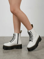 Side view of white leather lace-up platform boots worn with bare legs, showing chunky ridged sole and zip fastening