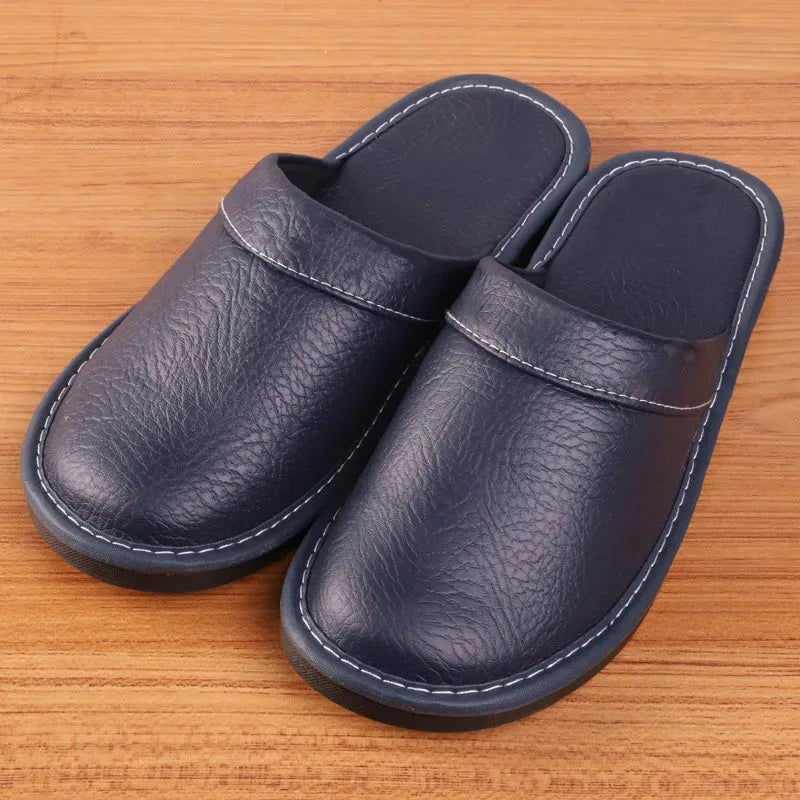 Front view of brown leather slippers lined up with books, showing rounded toe shape
