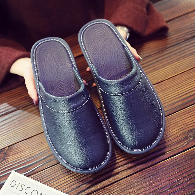 Underside angle of brown leather slippers highlighting the textured non-slip rubber sole