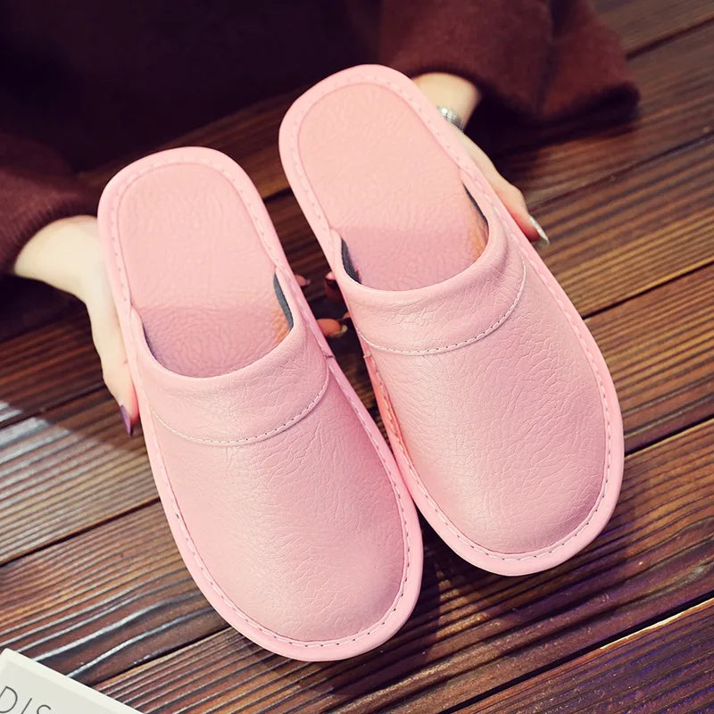 Three-quarter view of brown leather slip-on slippers showing depth of the cushioned footbed
