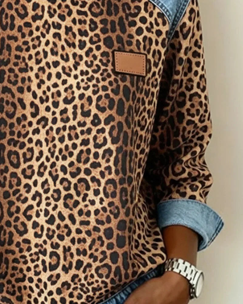 Side detail of brown leopard print sweatshirt sleeve with folded denim cuff and leather patch on chest
