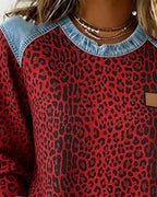 Front view of red leopard print jumper with denim shoulder panels and rounded hem