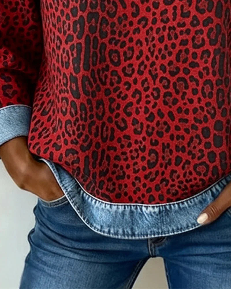 Close-up of denim crew neckline and red leopard print fabric with leather patch on chest