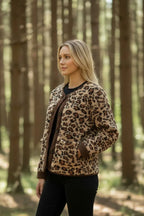 Side profile of the leopard print fleece jacket highlighting the brown corduroy cuff and textured fabric detail.