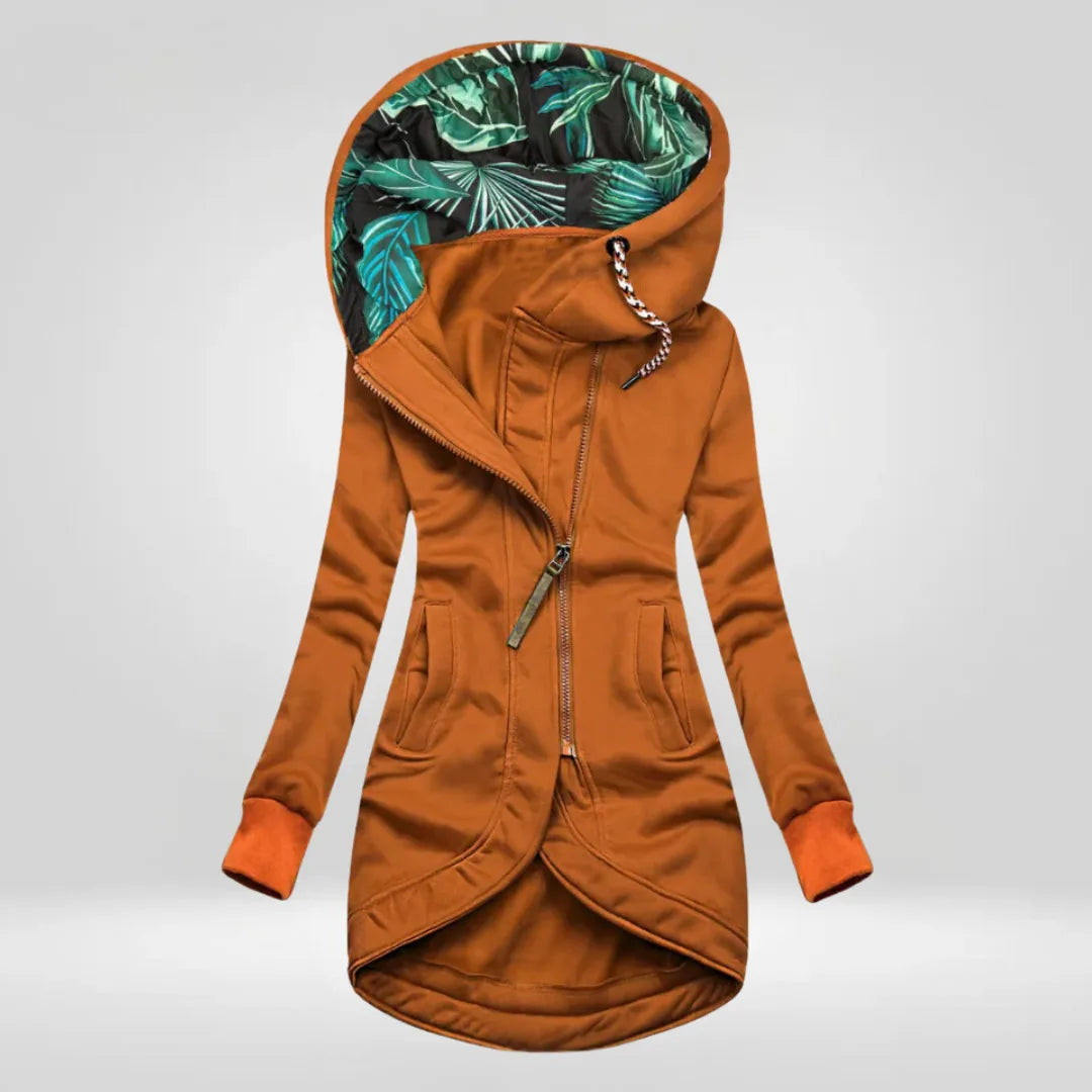 Rust orange hooded coat with contrast cuffs and tropical leaf print lining inside the hood