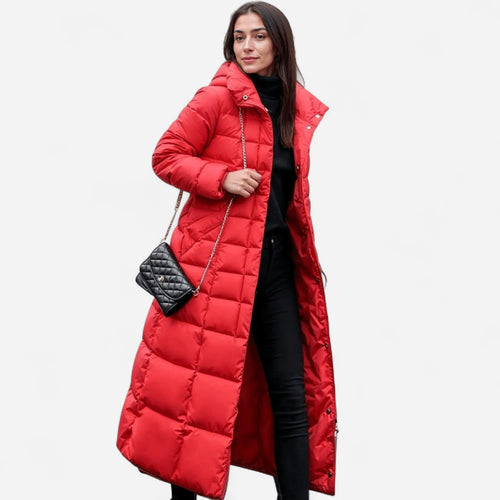 Front view of a red quilted longline puffer coat worn open over a black jumper and trousers