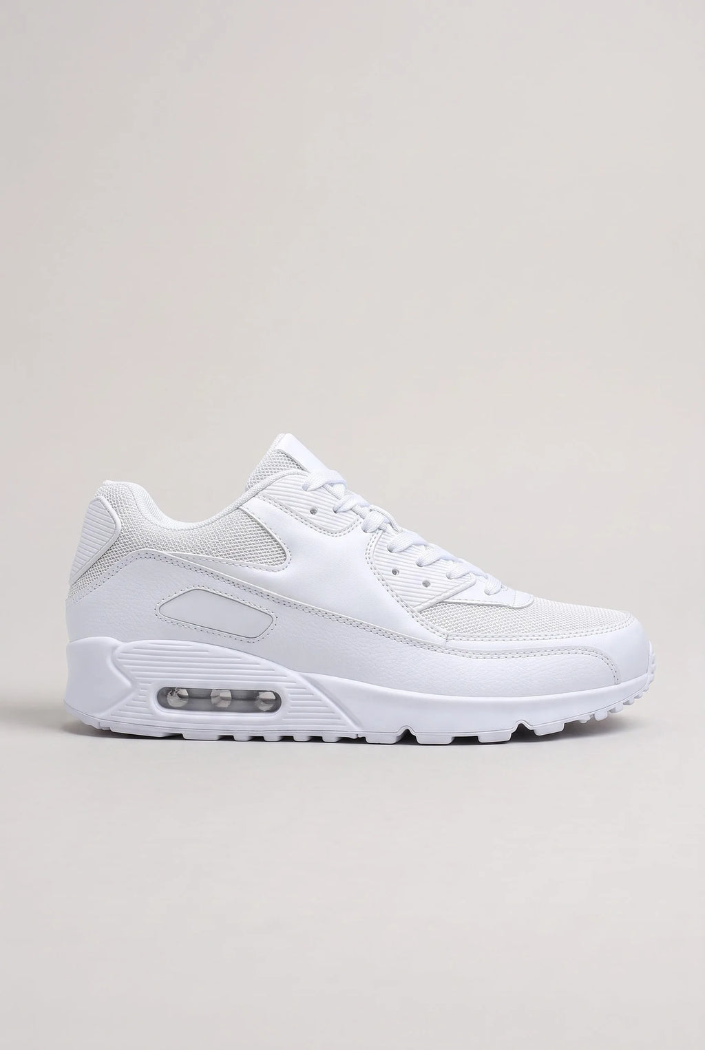 Side profile of white mesh and synthetic leather trainer with visible air-cushioned heel unit on a plain background