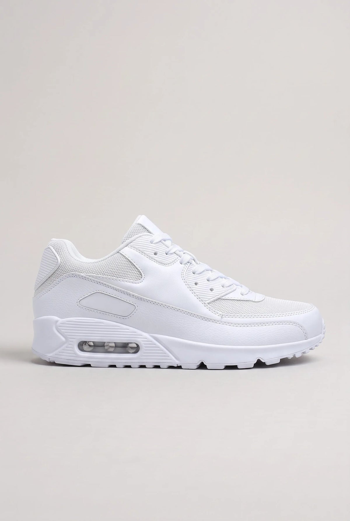 Side profile of white mesh and synthetic leather trainer with visible air-cushioned heel unit on a plain background