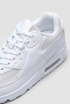 Close-up detail of the white trainer's lacing, mesh panels and textured heel support on toe