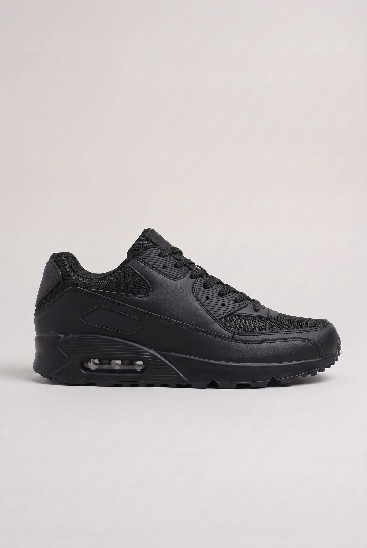 Side profile of all-black mesh and synthetic leather trainer with matching black cushioned outsole