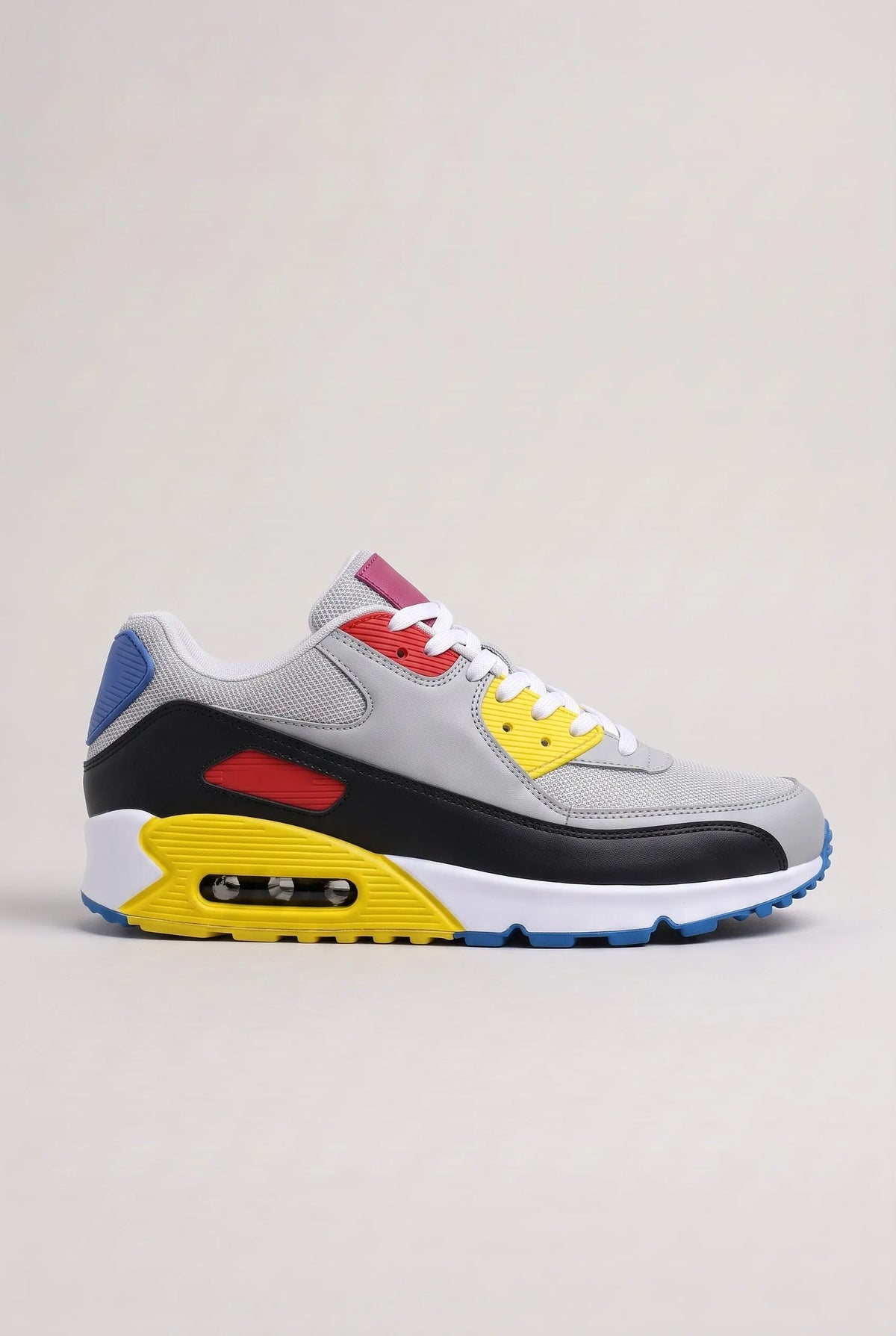 Side view of grey mesh trainer with black, red, yellow and blue colour-block panels and white midsole