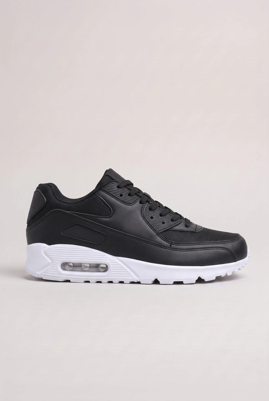 Side profile of black trainer with contrasting white air-cushioned sole and rubber outsole