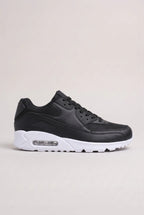 Side profile of black trainer with contrasting white air-cushioned sole and rubber outsole