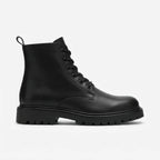 Side profile of a black leather combat boot with lace-up front, round toe and chunky lug sole on a plain background