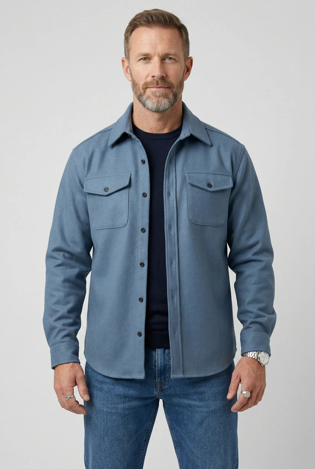 Man wearing a light blue brushed overshirt with chest pockets, open over a navy T-shirt and jeans