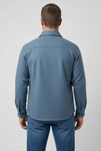 Rear view of the light blue overshirt showing the collar, shoulder seam and buttoned cuff