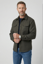 Man wearing an army green brushed overshirt with chest pockets over a navy T-shirt and jeans