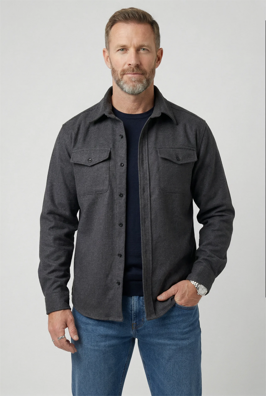 Man wearing a dark grey marl brushed overshirt buttoned over a navy T-shirt and jeans