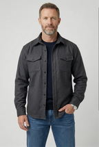 Man wearing a dark grey marl brushed overshirt buttoned over a navy T-shirt and jeans
