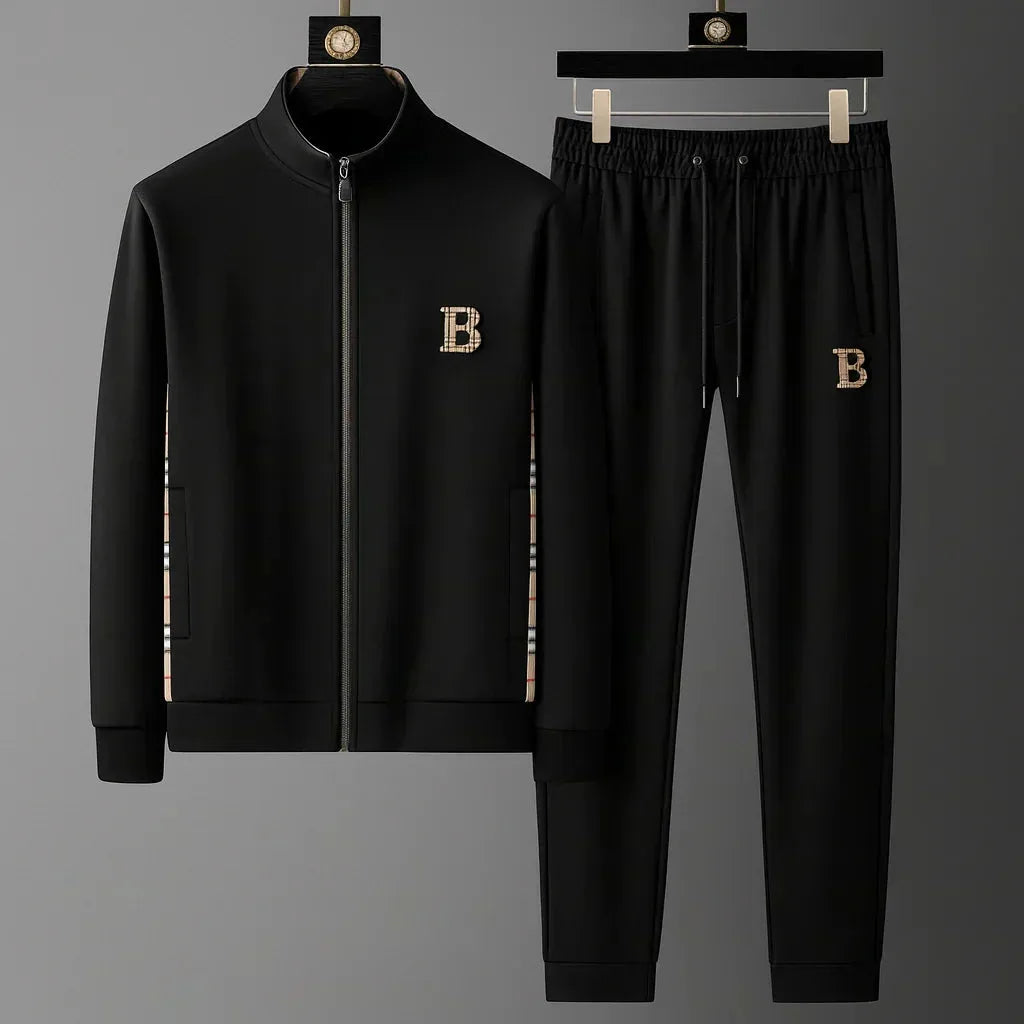 Black full-zip tracksuit jacket and joggers on hangers, showing checked side inserts and embroidered B crest
