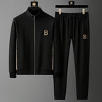 Black full-zip tracksuit jacket and joggers on hangers, showing checked side inserts and embroidered B crest