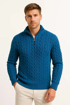 Deep teal cable-knit quarter-zip jumper worn with cream trousers, front facing view