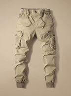 Flat lay of beige cargo joggers with drawstring waist, ribbed cuffs and buttoned flap pockets