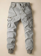 Flat lay of light grey cargo joggers showing side cargo pockets with zip and button fastening