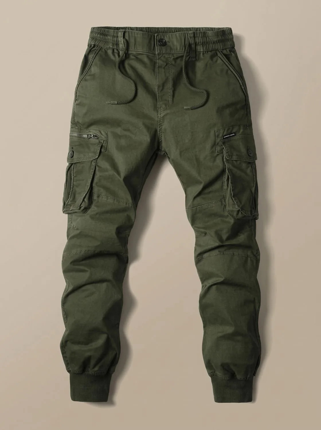Flat lay of olive green cargo joggers with zip and button cargo pockets and elastic cuffed hems