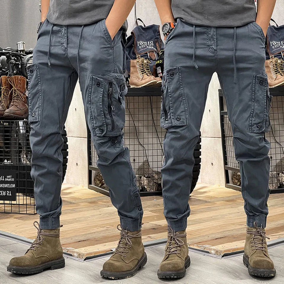 Back and side view of slim-fit grey cargo joggers showing buttoned side pocket flap and elastic cuffed hem