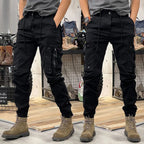 Front and rear view of black cargo trousers with tapered leg, multiple pockets and adjustable ankle straps
