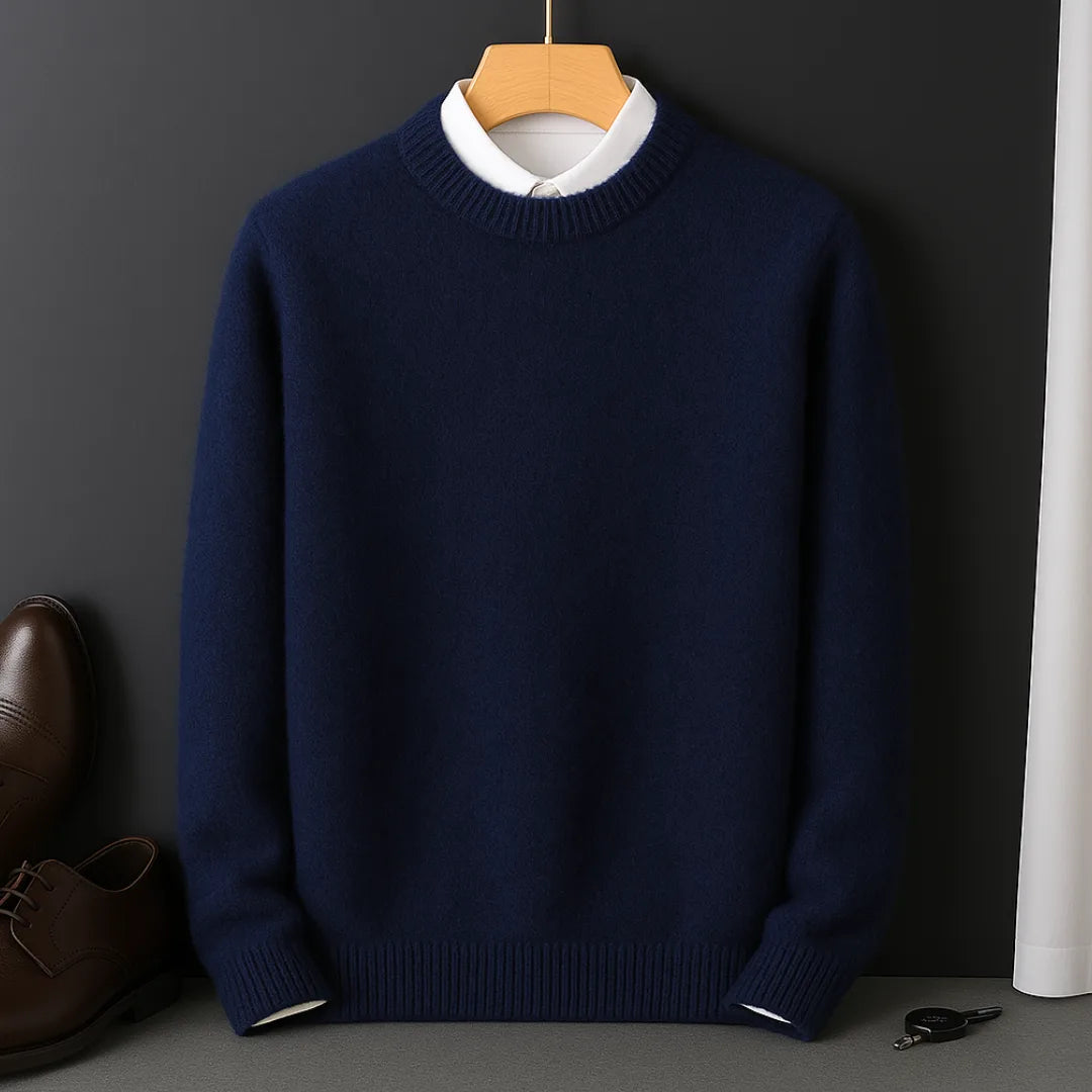 Navy blue knitted jumper on a wooden hanger, layered over a cream collared shirt, front view